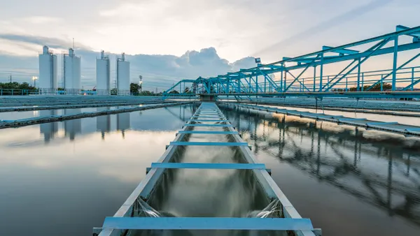 Water treatment plant infrastructure with the sun rising behind it.