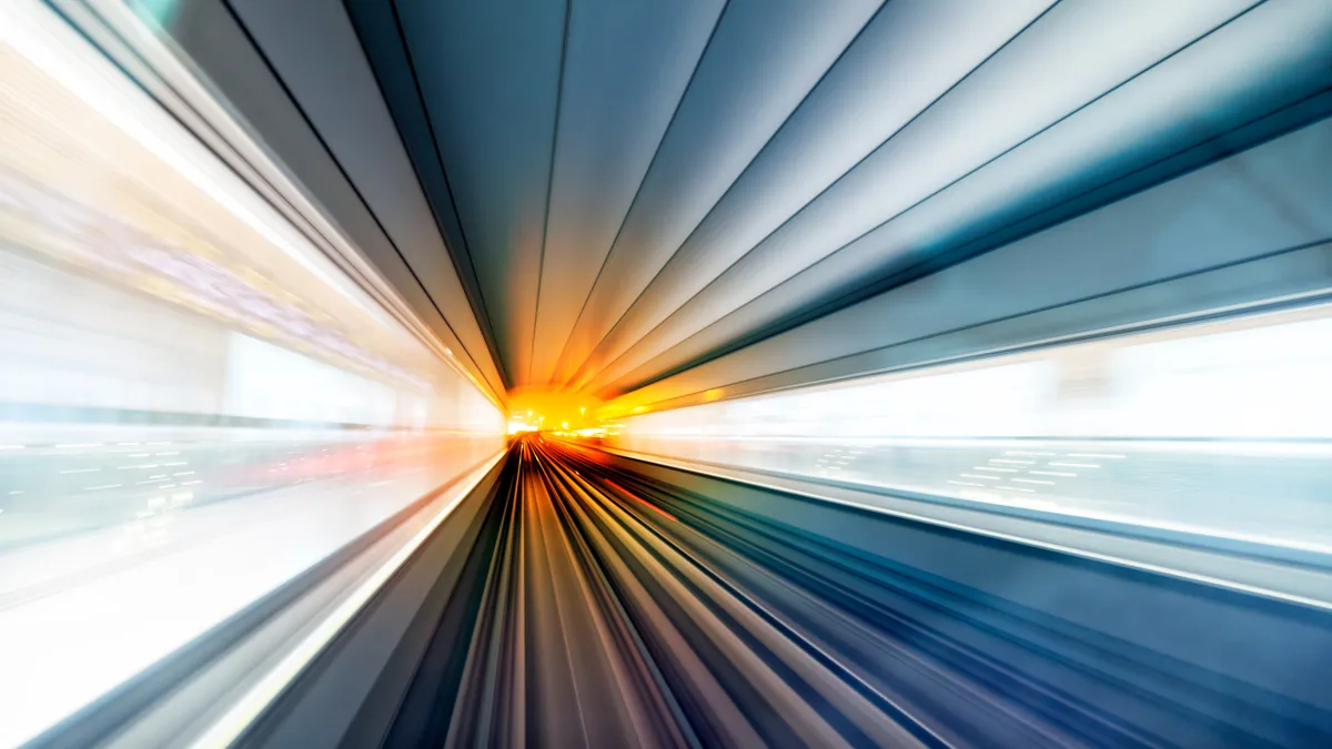 Abstract, multicolored, motion blurred railroad tracks and light trails in a tunnel.