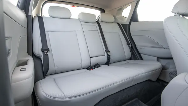 The rear seats in a 2026 Hyundai Kona SUV showing the retracted seat belts and three headrests.