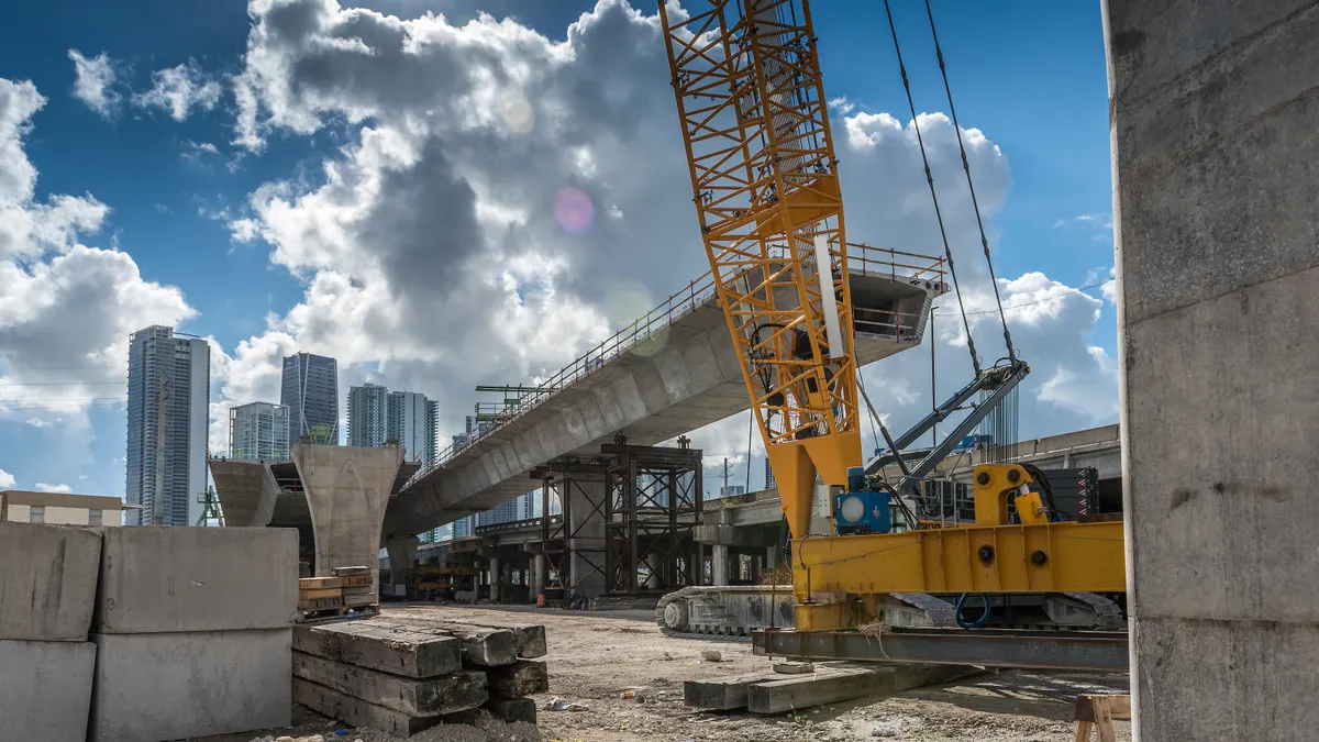 Heavy machinery and workers working on the construction of a new viaduct along the north of downtown Miami