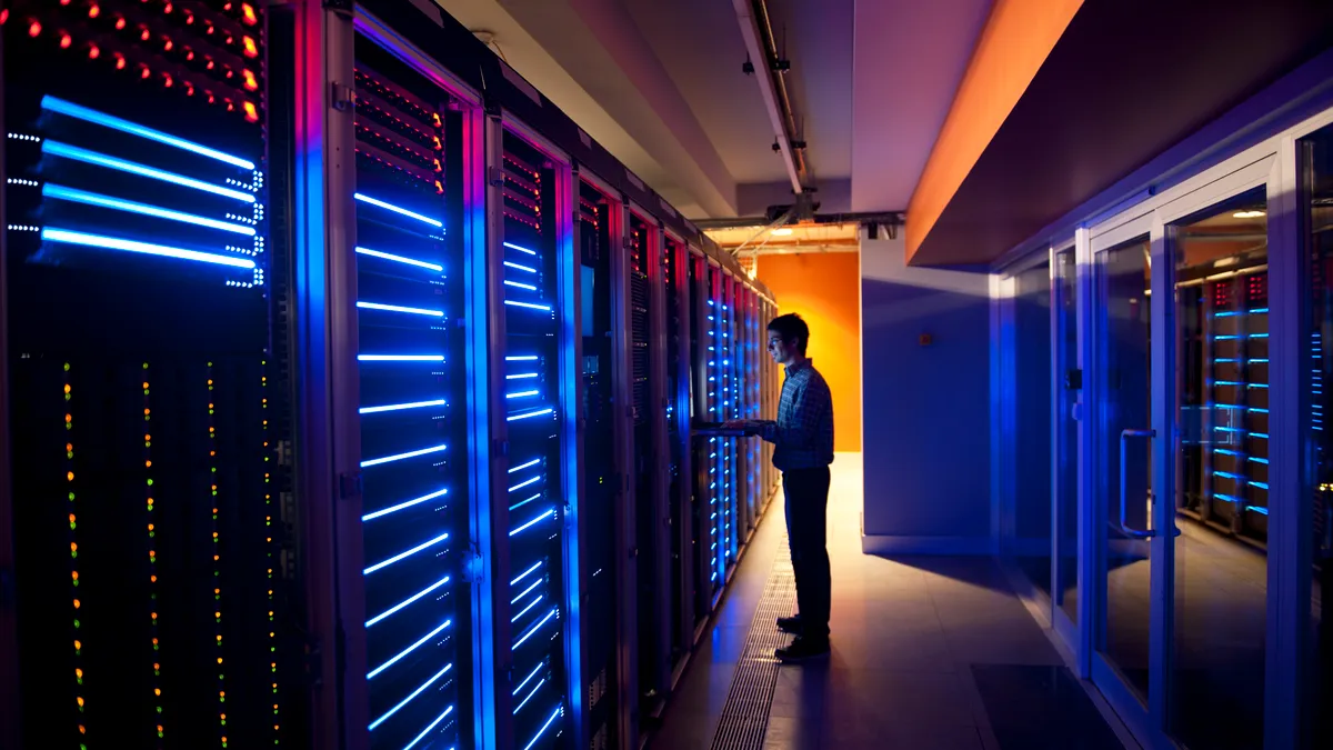 Person working on servers in a server room.