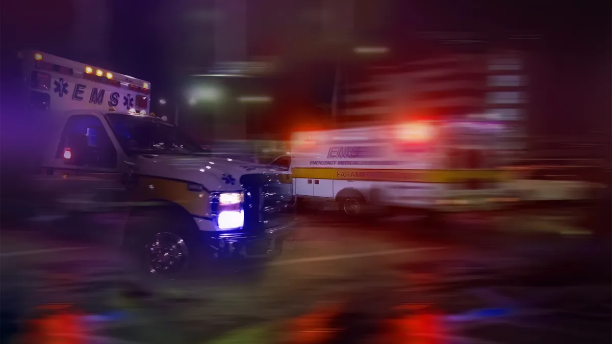 An ambulance speeding through traffic at night.