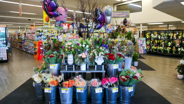 Floral display inside grocery store with fresh bouquets and butterfly balloons