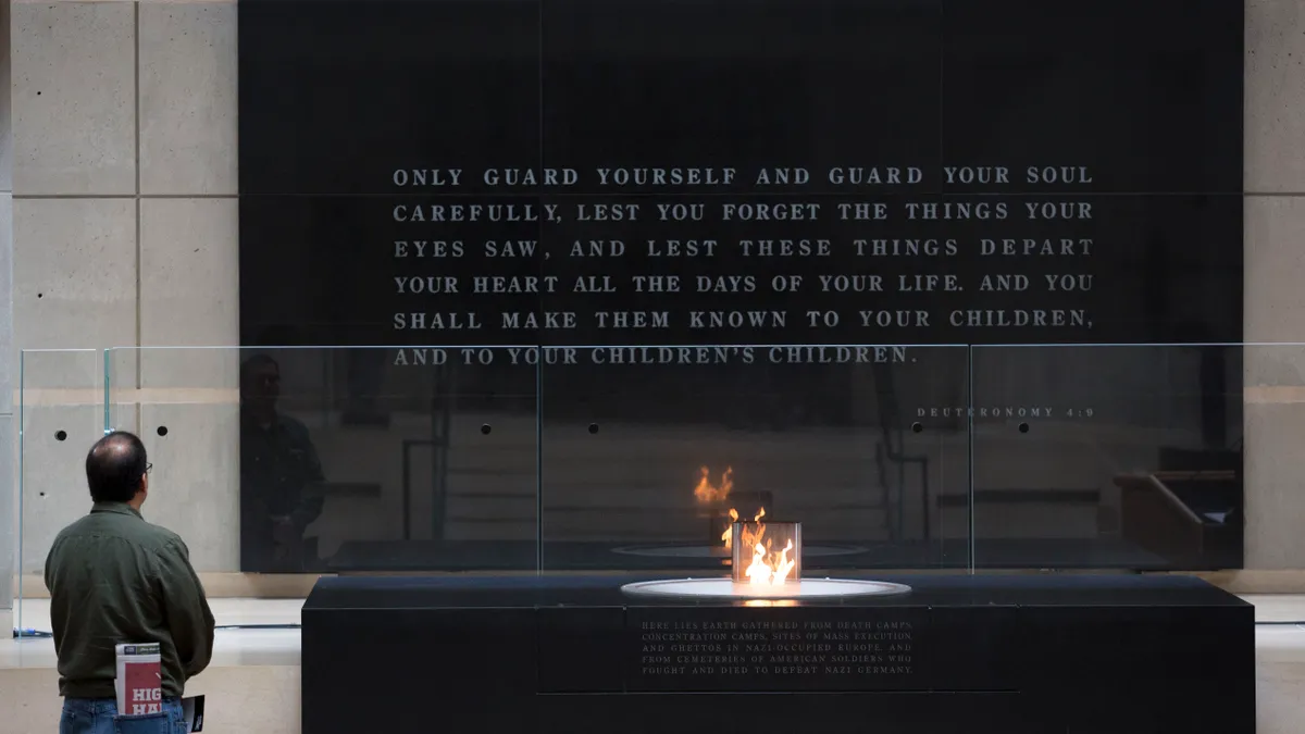 A man pauses in front of the eternal flame in the Hall of Remembrance at the U.S. Holocaust Memorial Museum