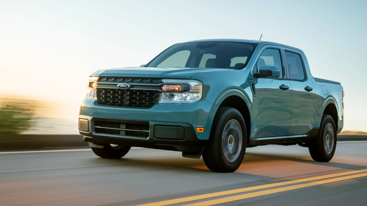 A light green 2022 Ford Maverick hybrid pickup truck on a highway.