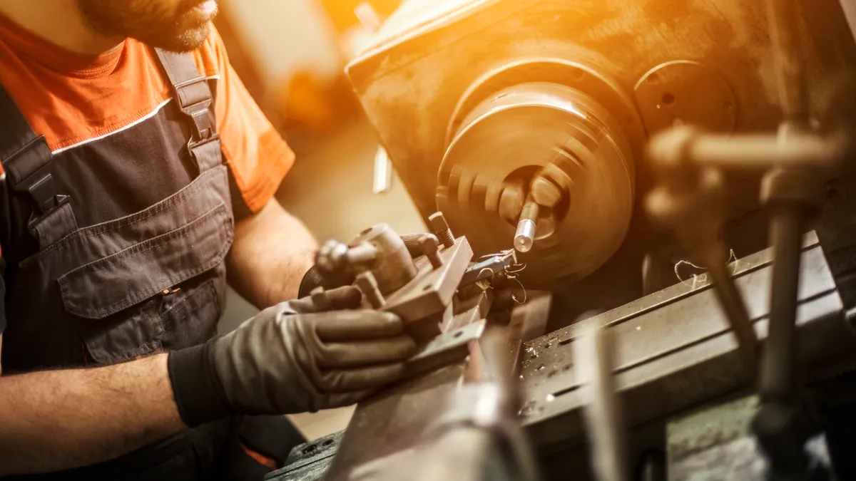 A man using a manual metal manufacturing process.