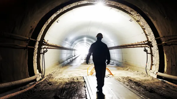 A worker walks through a tunnel under construction.