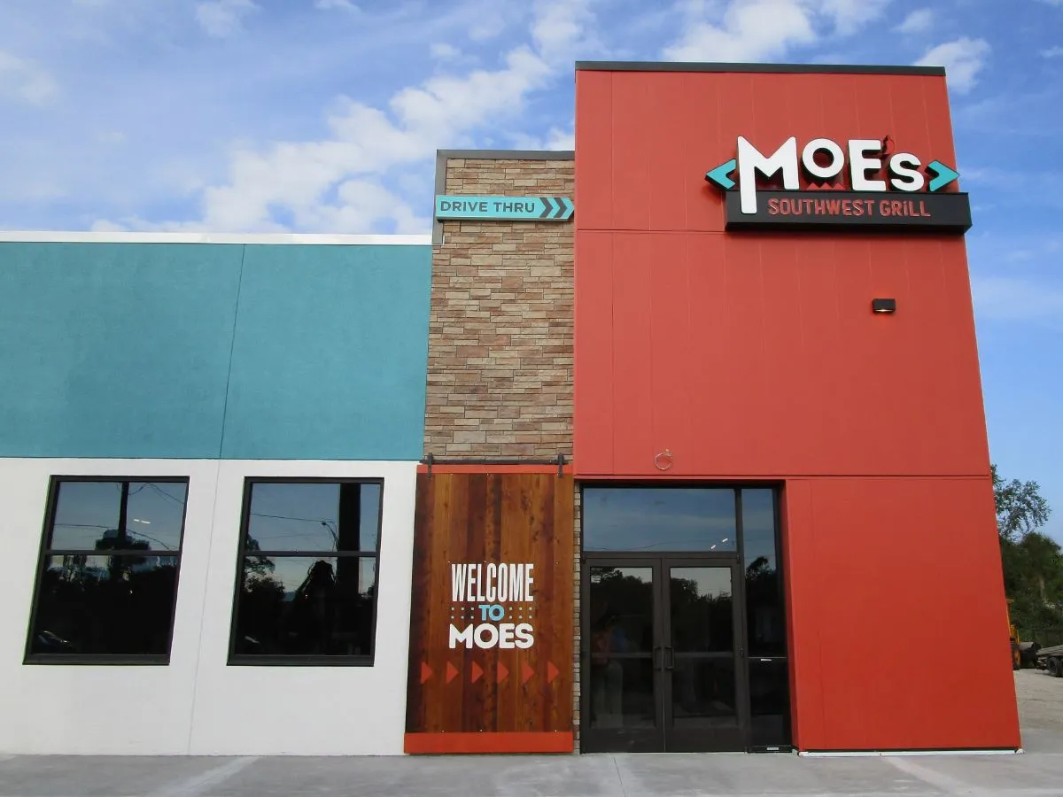 An image of a red, turquoise and white restaurant with Moe's signage