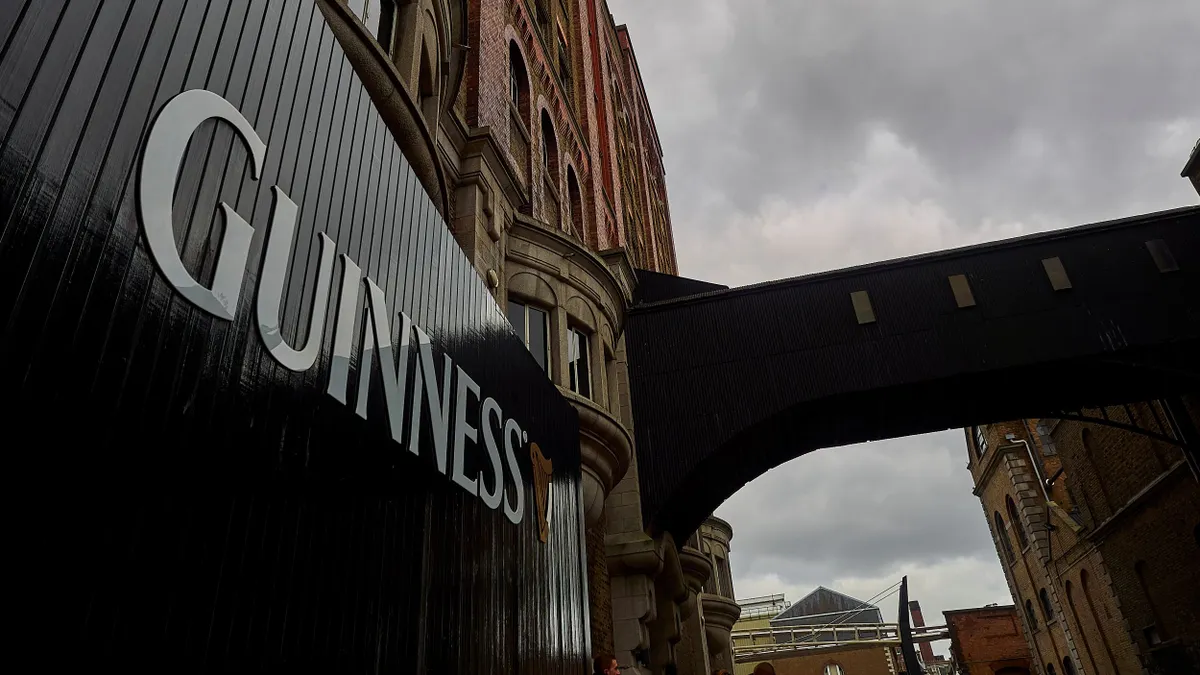 A gate that reads Guinness in front of the brewery.