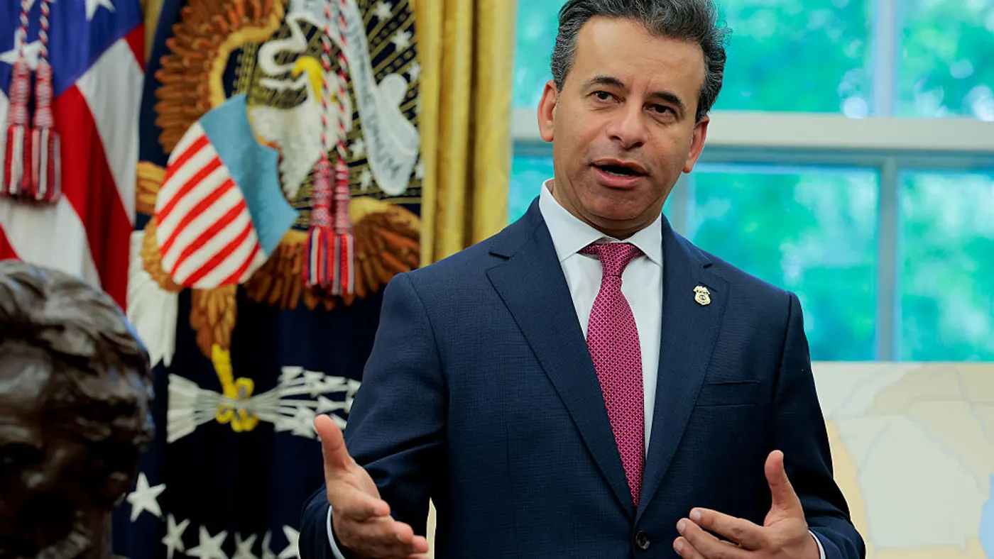 man in a dark blue suit speaks in the oval office