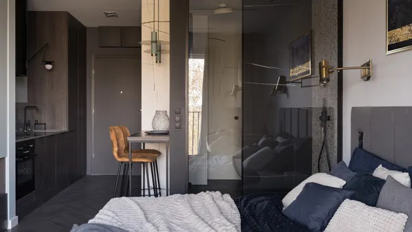 A studio apartment with a blue and black color palette.