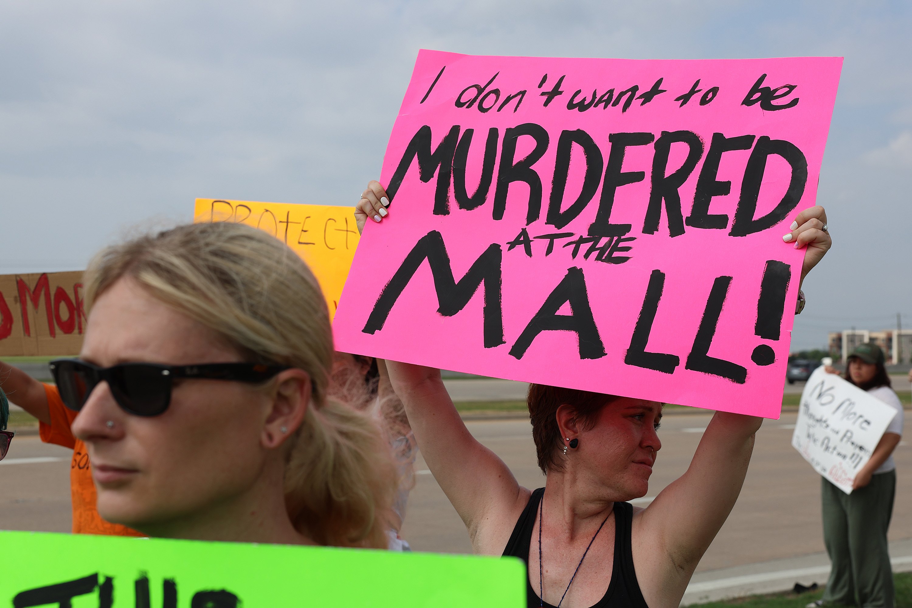 People holding up signs protesting gun violence.