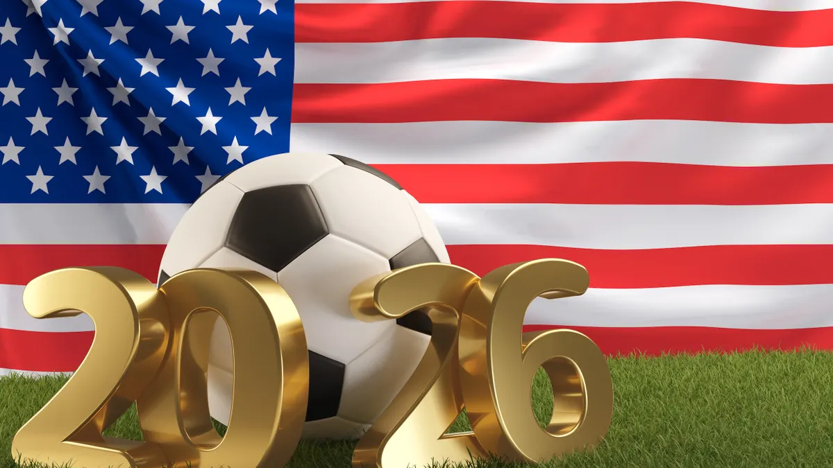 A soccer ball and bronze "2026" lettering in front of an American flag.