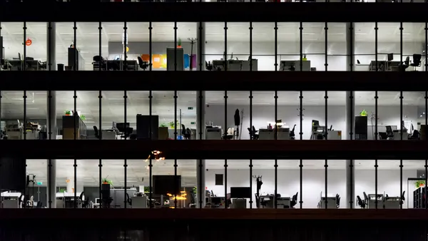 Detail of an office building in the night, illuminated with indoor lights.
