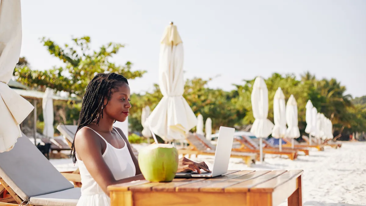 A person works remotely on a beach