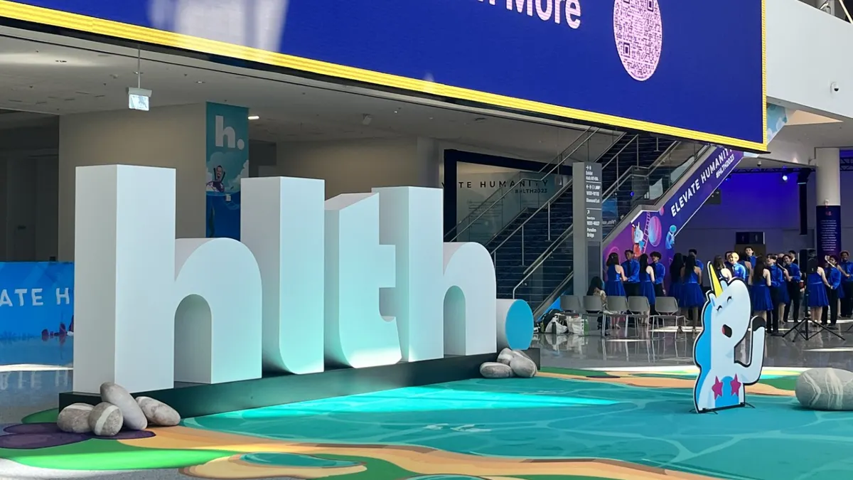 HLTH's logo in white block letters at the entrance to the conference, flanked by HLTH's unicorn mascot.