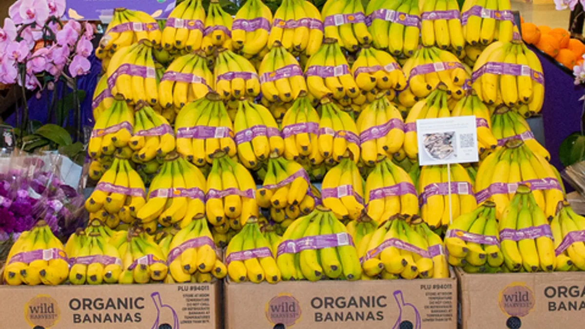 Bunches of bananas in cardboard boxes labeling them as organic.