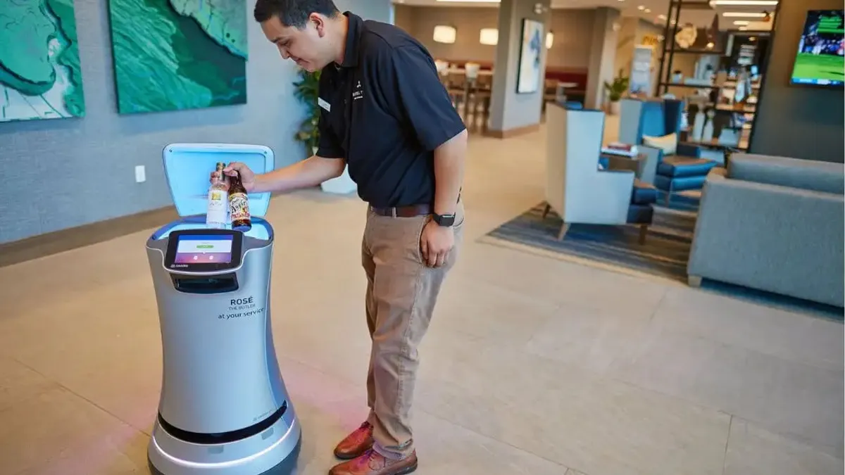 A staffer at the Hotel Trio Healdsburg places drinks within a Relay robot.