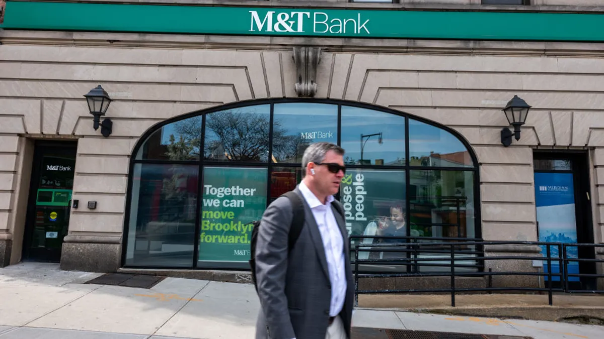 A bespeckled man walks in front of M7T Bank in Brooklyn, NY.