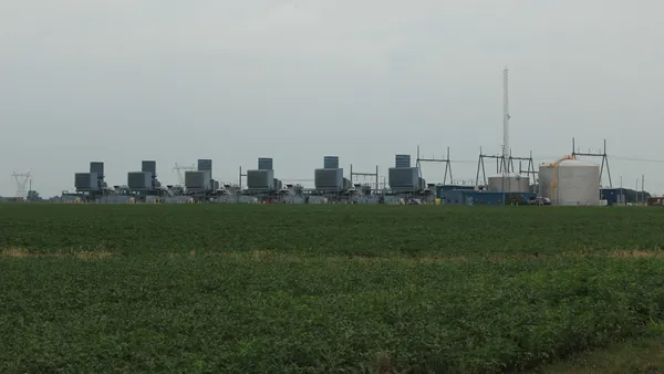 A power plant at the edge of a field.