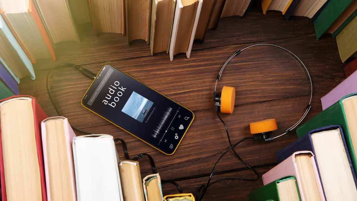 Shot of phone with headphones surrounded by books