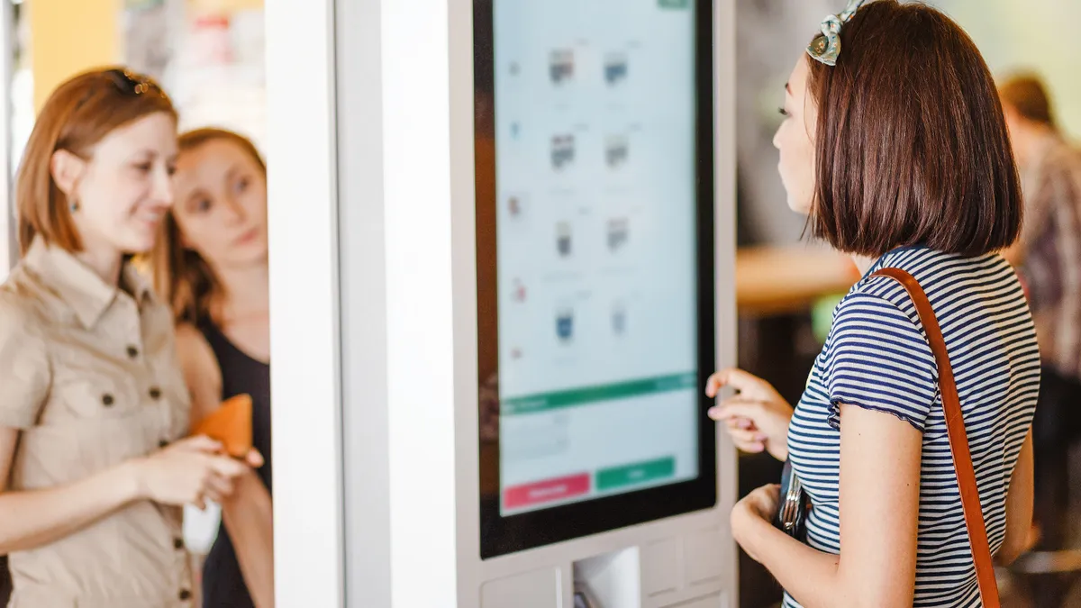 Three people at self-serving kiosk