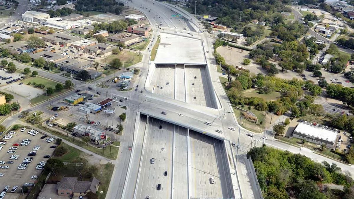 Aerial view of a long grey multi-lane highway.