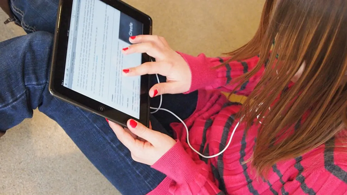 A student uses an iPad in school to work on a class project.