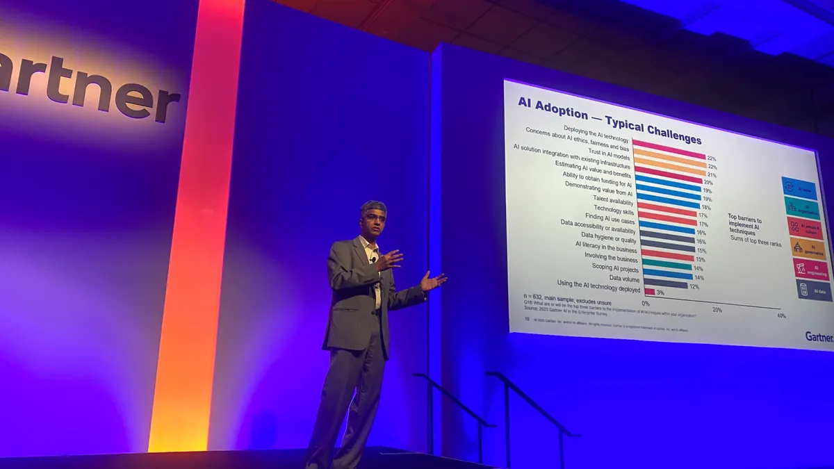 An analyst gives a presentation onstage about enterprise AI adoption.