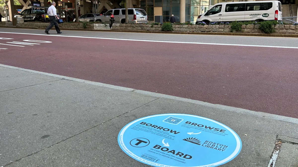 A circular decal on the sidewalk by the road