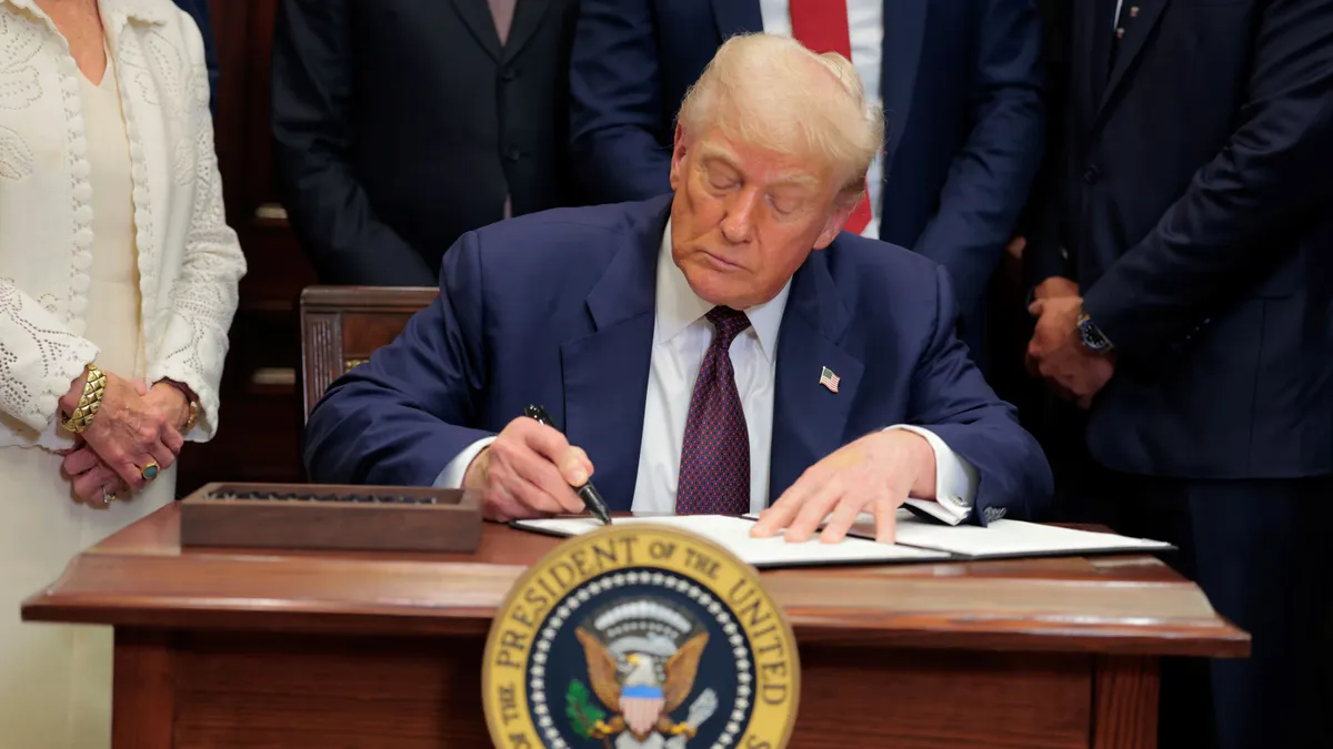 President Donald Trump signs an executive order at the White House on July 31, 2025.
