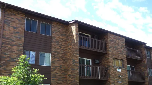 A garden-style brick apartment building.