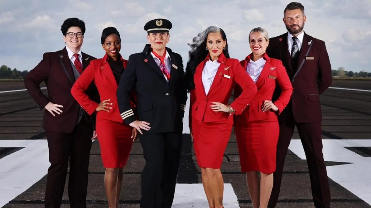 Virgin Atlantic employees and a media personality wear various combinations of the company's burgundy and red uniforms.