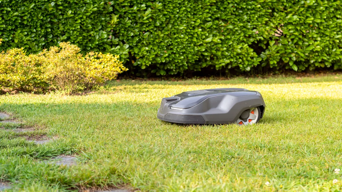 A robotic lawn mower cutting grass in a garden.