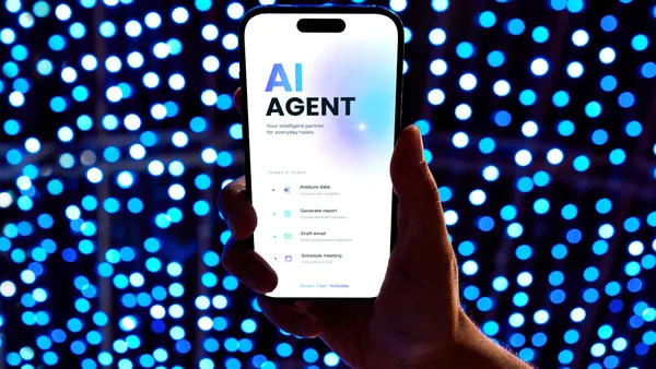 Hand holding modern smartphone with an AI agent application on screen.