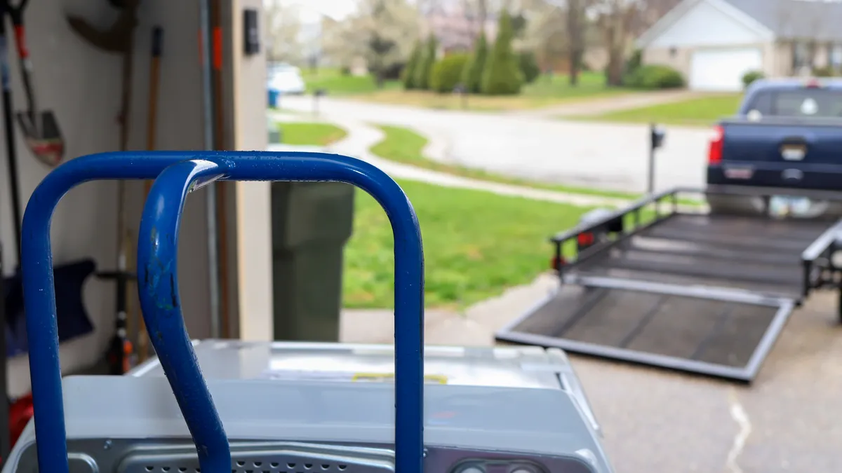 A close up of a washing machine being delivered on a trolley