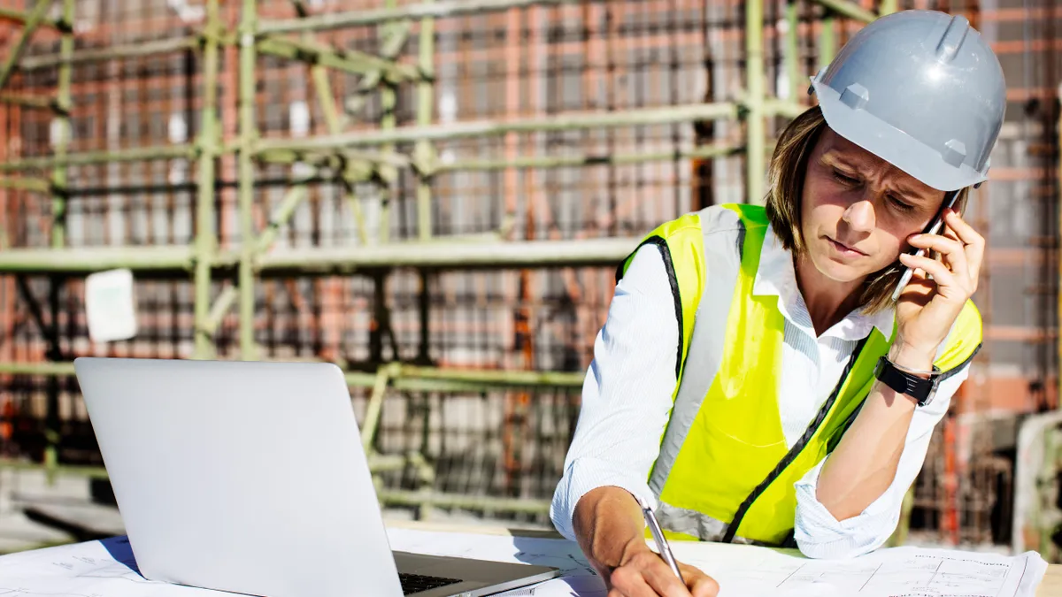 Female architect using mobile phone while working at construction site