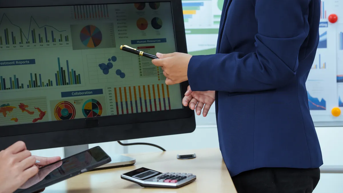 Two young businesswomen sit at a table, engaged in a meeting.examine graphs and discuss capital investment strategies, showcasing their expertise and collaborative approach to business growth.