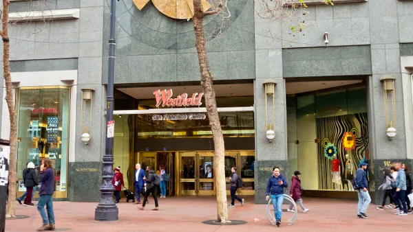 The entrance to a downtown mall, with people walking by.