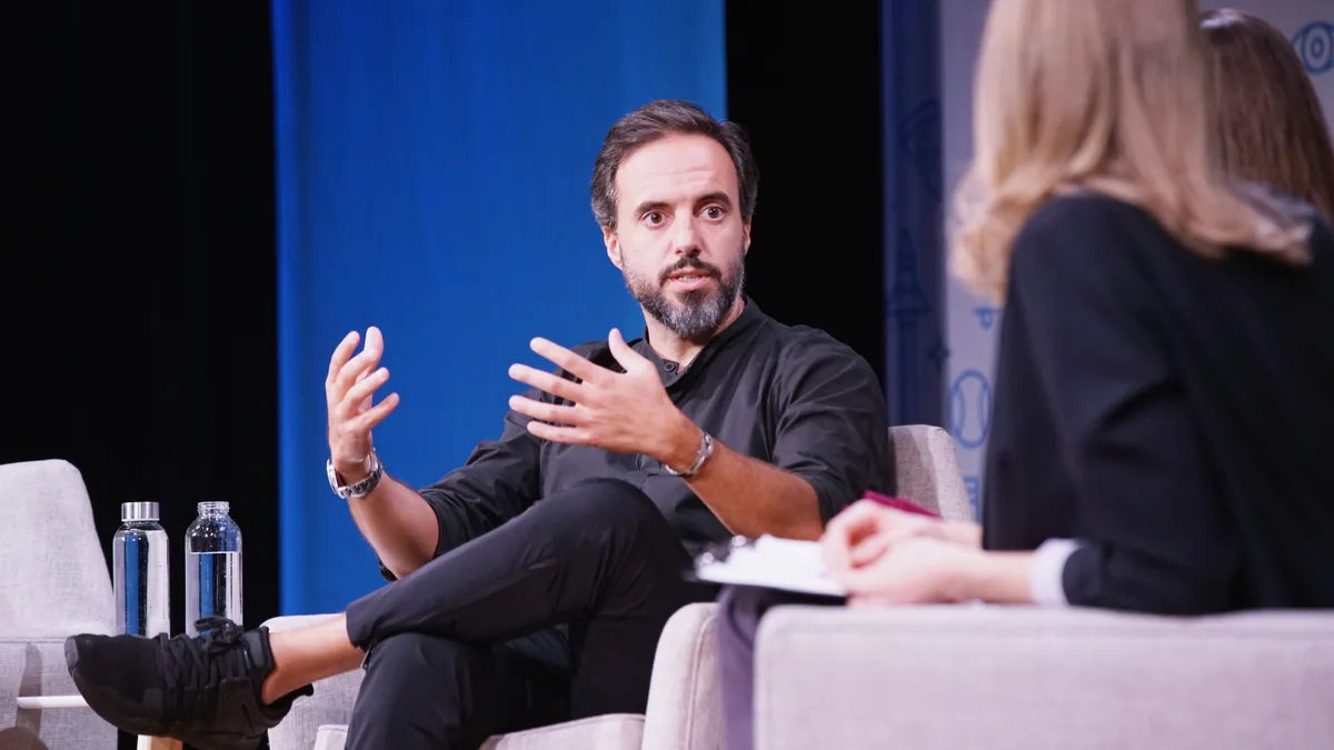 Jose Neves, CEO and founder of Farfetch, speaks at an event on a stage.