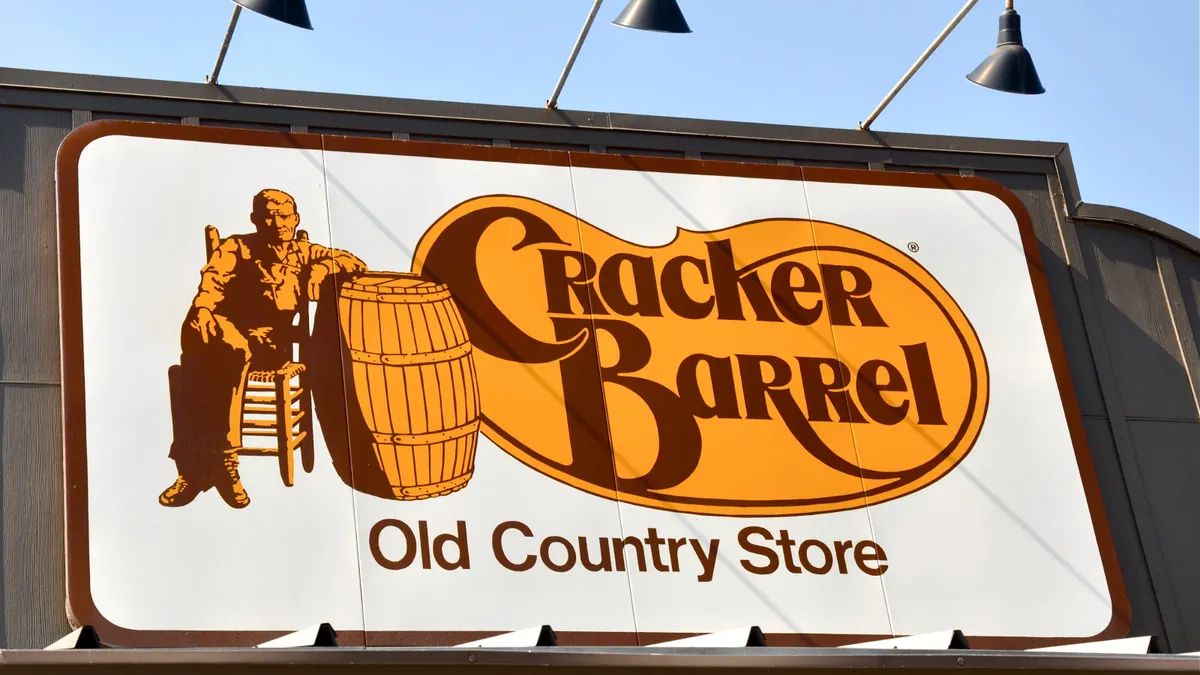A photograph of a rectanguler sign with a Cracker Barrel logo and its Uncle Herschel mascot