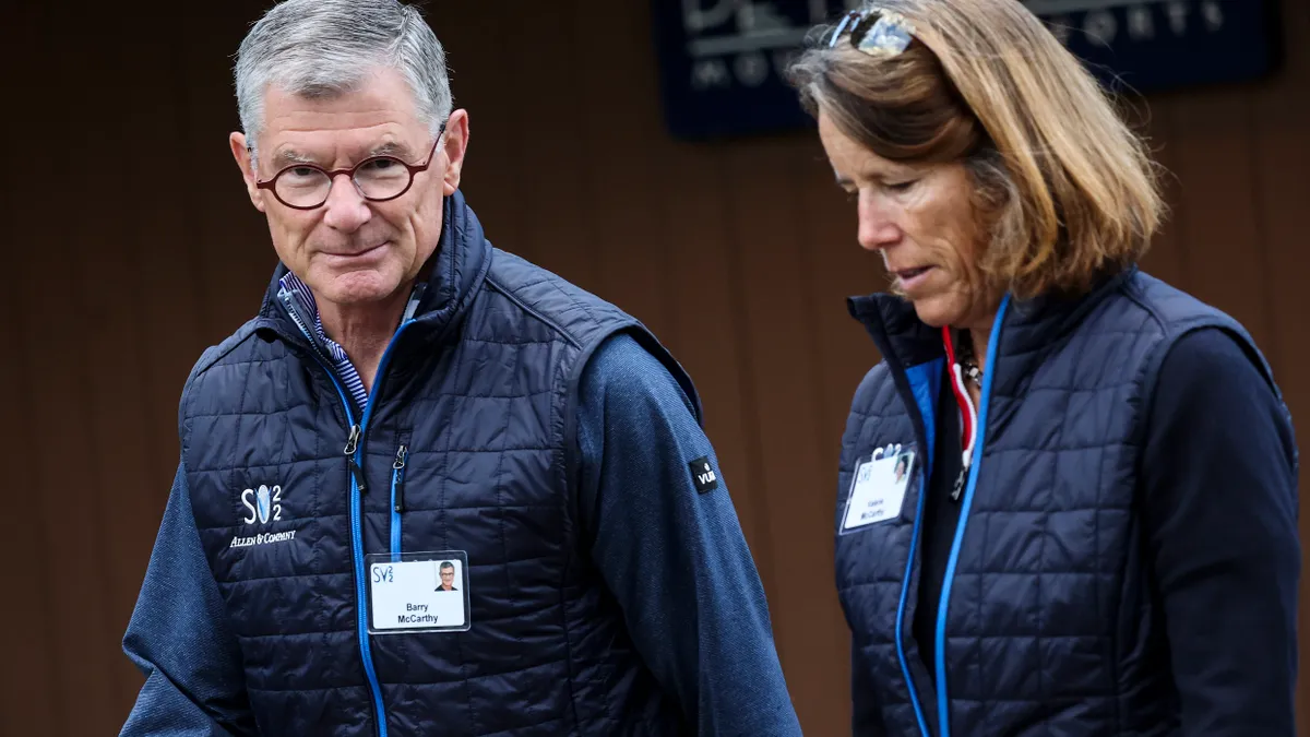 Peloton CEO Barry McCarthy in a blue vest and glasses.