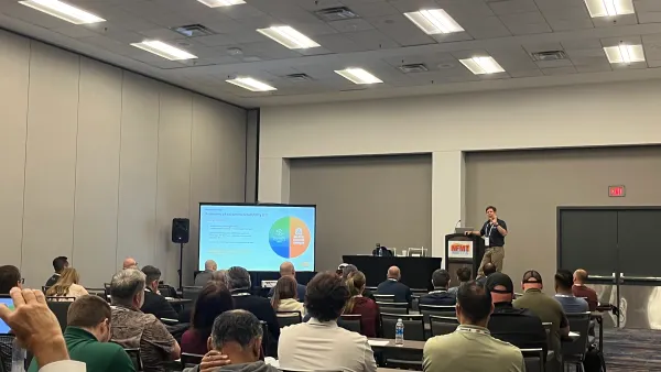 Attendees sit in a lecture room and listen to a presentation on peak energy demand charges.