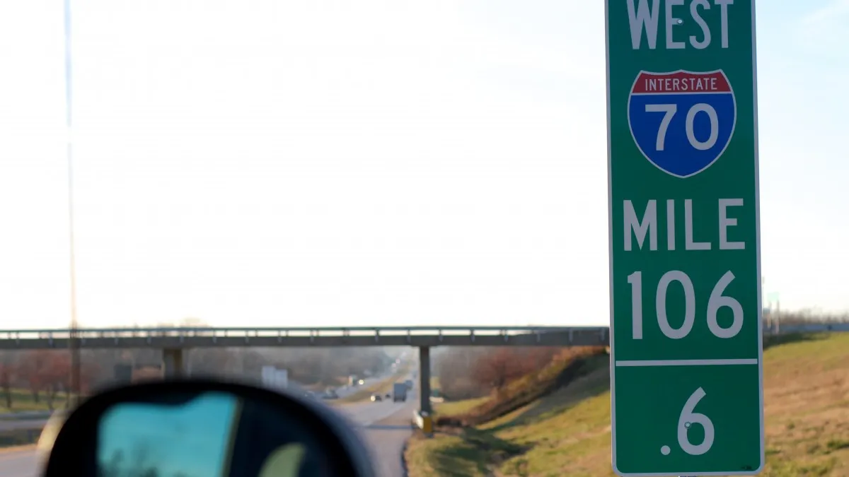 Green mile marker 106 on I-70, with highway stretching into the background.