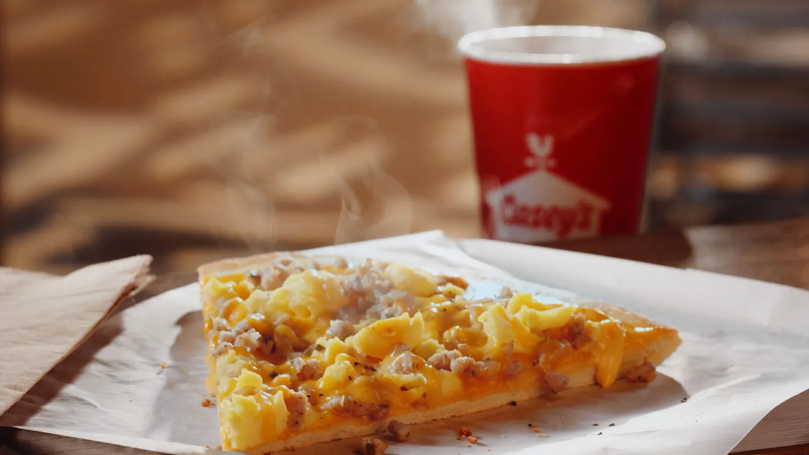 A photo of a slice of breakfast pizza and a cup of coffee from Casey's General Stores.