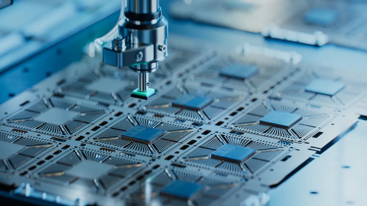 Close-up of silicon die being extracted from semiconductor wafer and attached to the substrate by a pick and place machine.