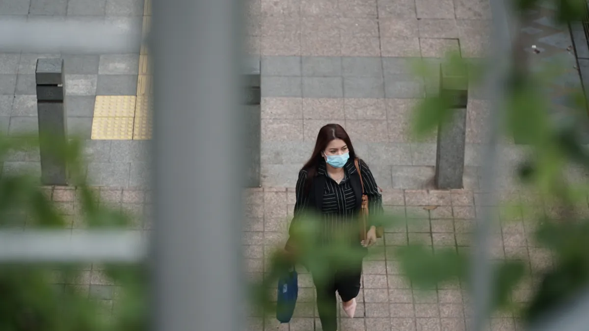 woman walking outside while wearing a facemask