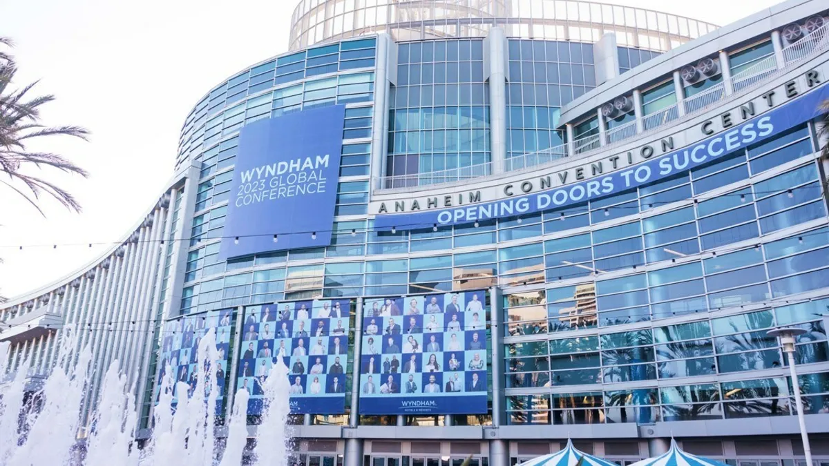 The glass exterior of the Anaheim Convention Center features blue signage denoting Wyndham's 2023 Global Conference.