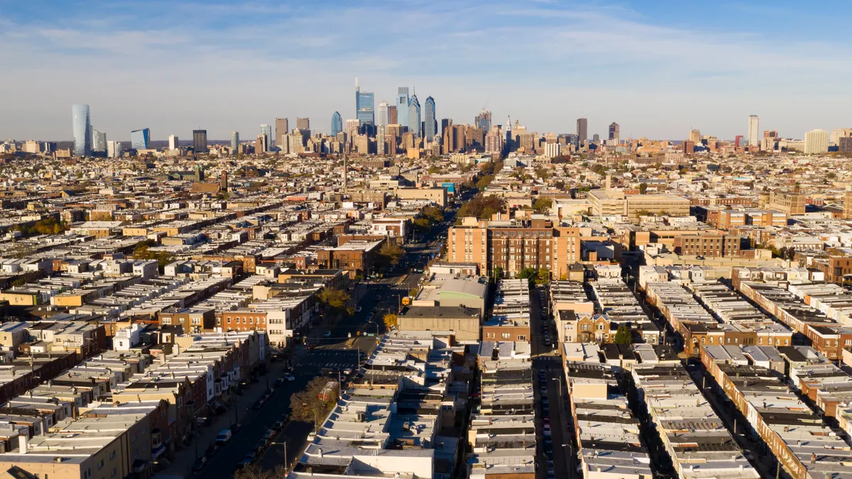 Wide view of row houses leading to skyline of downtown Philadelphia.