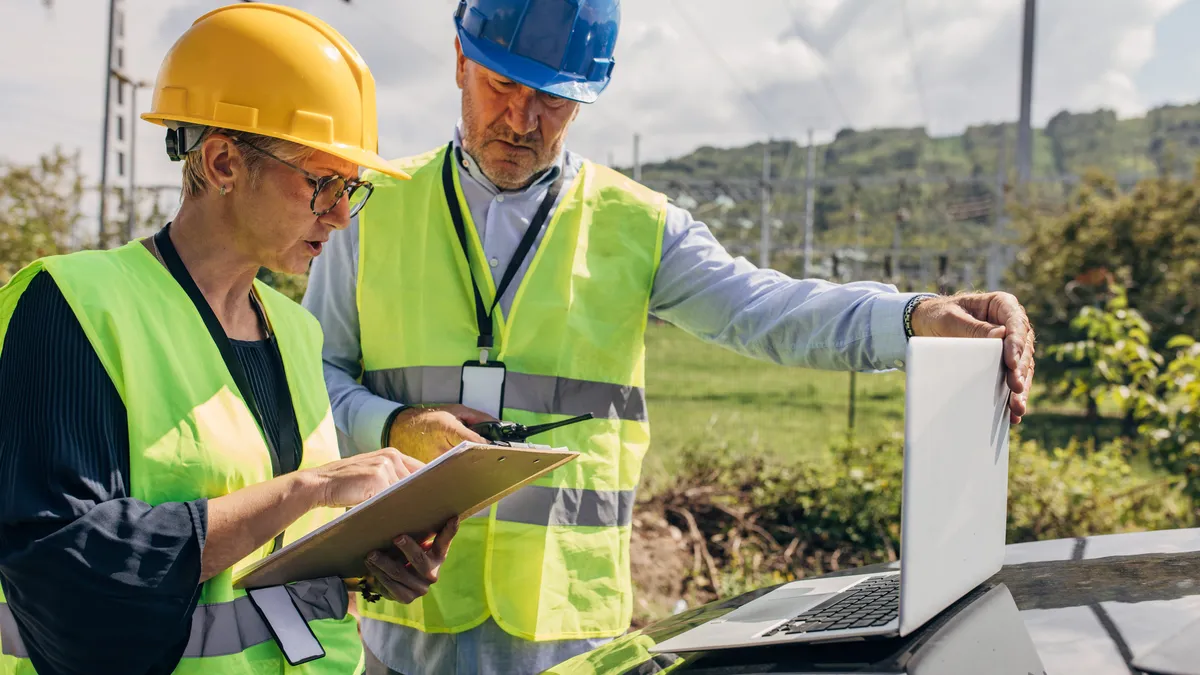 Electrical Engineers Using Laptop In Power Station.